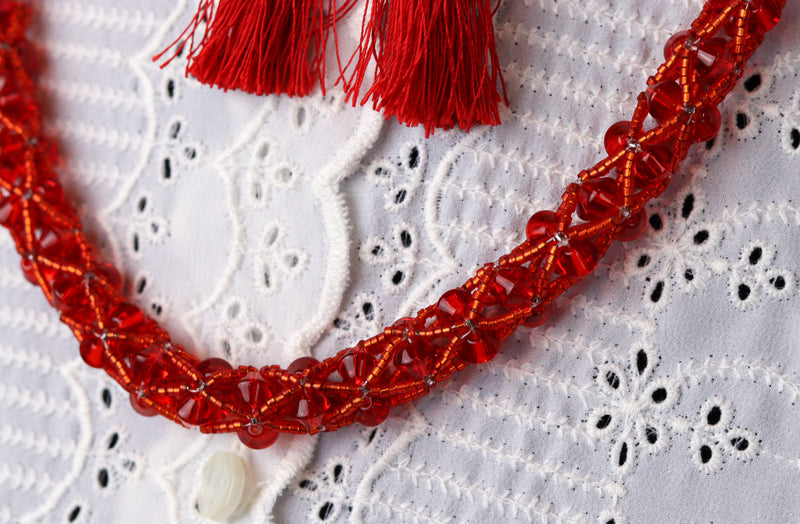 赤いビーズのかぎ針編みのネックレスと赤いタッセルのイヤリングのセット